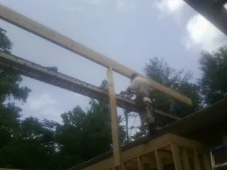 Carpenter setting a ridge beam over a new addition frame — Ice Dam Removal by Roofing Brothers in French Camp