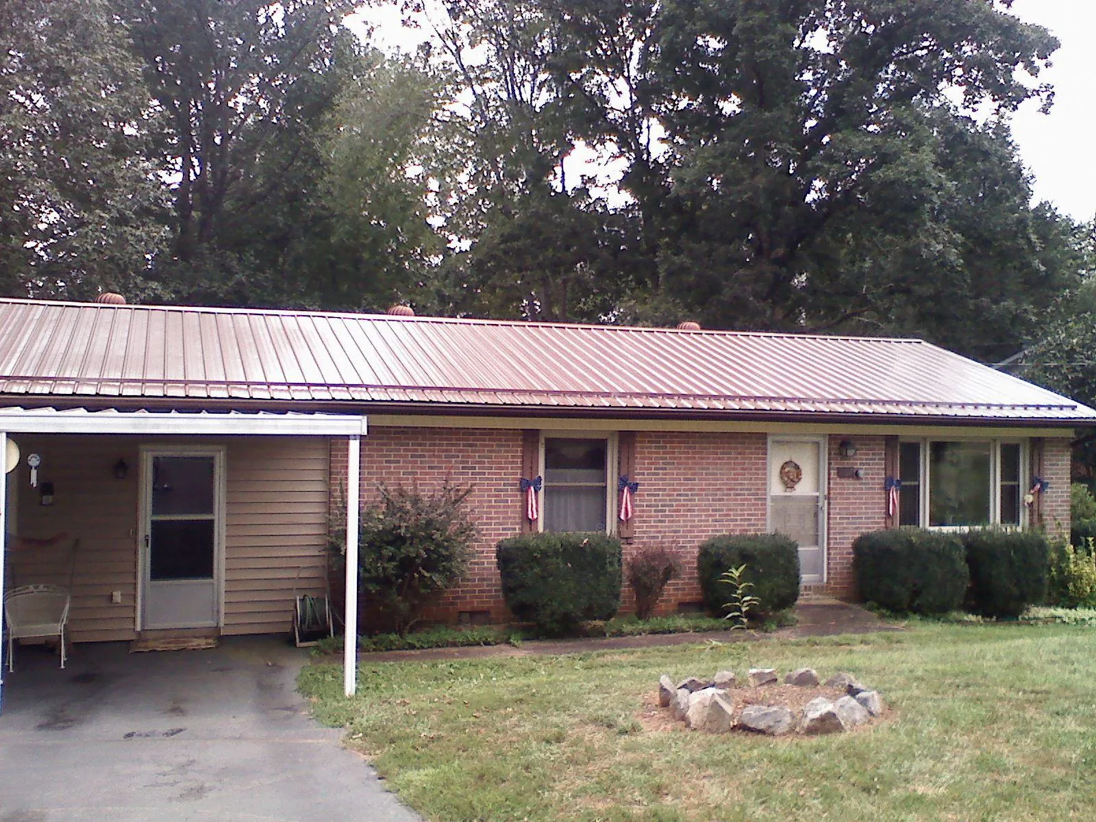 Bronze metal roof and carport on a brick ranch home — Roof Repair work by our crew in French Camp